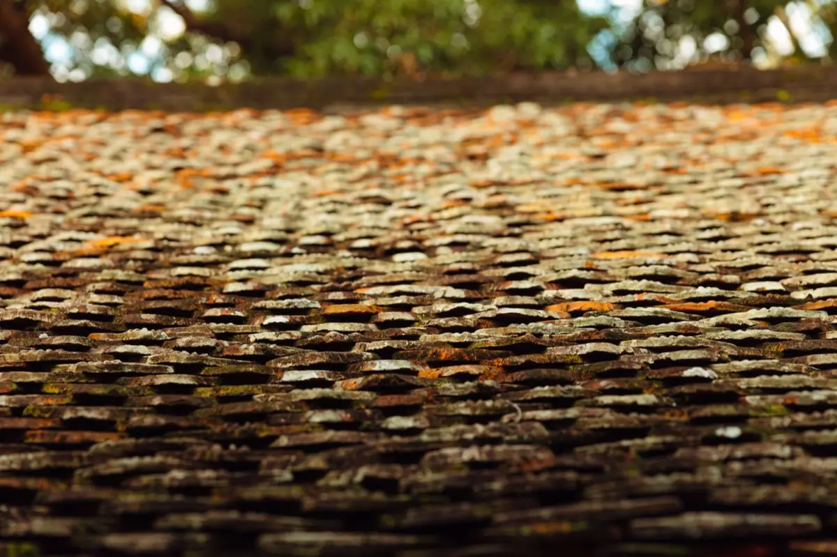 Aging shingle roof with moss growth and granule loss in Broken Arrow, OK